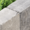 graue Betonpalisade mit strukturierter Oberfläche als Beetbegrenzung im Garten