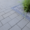 Graue Pflastersteine auf Terrasse mit Beetrand aus Beton und Kies