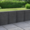 Anthrazitfarbene Betonmauer zur Flächentrennung an einer Terrasse im Garten, Palibord