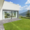 Terrassenplatten in Grau, vor moderner Terrasse mit Rasen und Bergblick