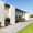 Moderne Terrassenanlage mit weißen Stützwinkeln, grauen Platten und angrenzendem Rasen