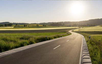 Bankettplatten entlang einer kurvigen Straße in ländlicher Landschaft