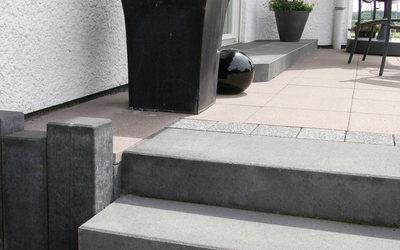 Graue Blockstufen an der Terrasse mit Pflanzkübel und Pflanzgefäß