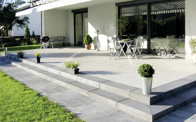 Grau verlegte Blockstufen an der Terrasse mit Gartenbereich