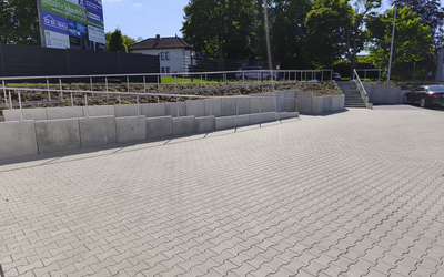 Doppel-T-Pflaster auf großer Einfahrt mit Stützmauer und Treppe im Außenbereich