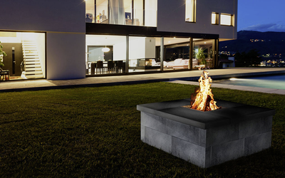 graue Feuerstelle aus Beton im Garten vor moderner Terrasse mit Flammen, Tribus-CityPur