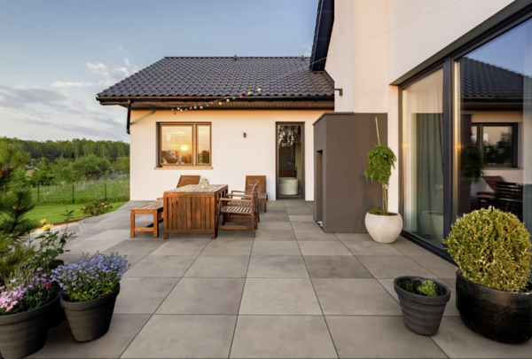 Großformatige graue Terrassenplatten in modernem Außenbereich neben einem Haus