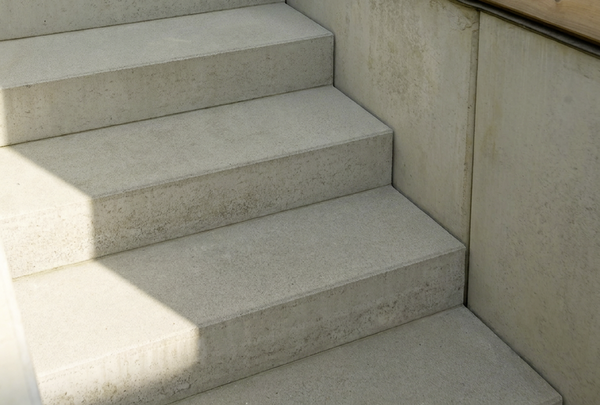 Graue Betonblockstufen als Treppe mit glatter Oberfläche im Außenbereich