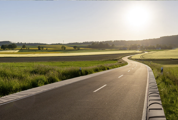 Bankettplatten entlang einer kurvigen Straße in ländlicher Landschaft