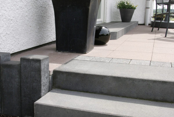 Graue Blockstufen an der Terrasse mit Pflanzkübel und Pflanzgefäß