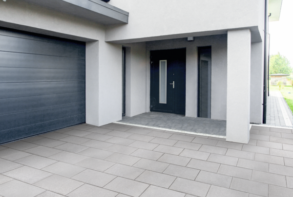 Terrassenpflaster in hellgrau, rechteckig verlegt vor moderner Hauseingangssituation