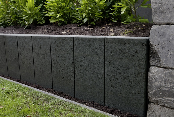 Anthrazitfarbene Beeteinfassung aus Beton mit senkrechten Platten im Gartenbereich, Palibord