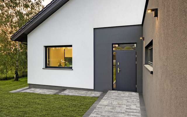 Pflasterweg aus hellgrauen Rechtecksteinen als Eingangszugang zum Haus, Gartenweg entlang der Fassade