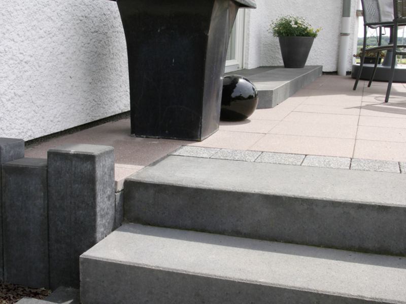 Graue Blockstufen an der Terrasse mit Pflanzkübel und Pflanzgefäß