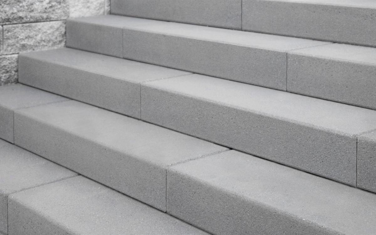 Graue Blockstufen aus Beton für Außentreppen mit glatter Oberfläche und geradliniger Verlegung