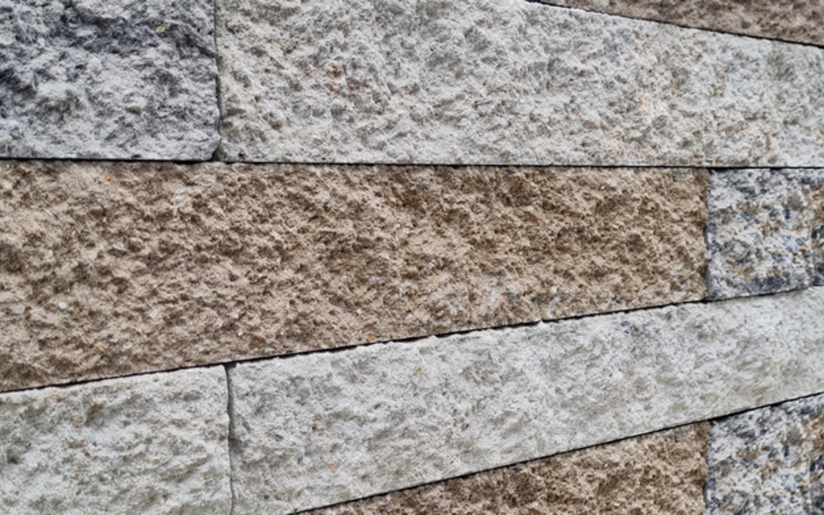 Mauer in Grau- und Beigetönen mit rauer Oberfläche
