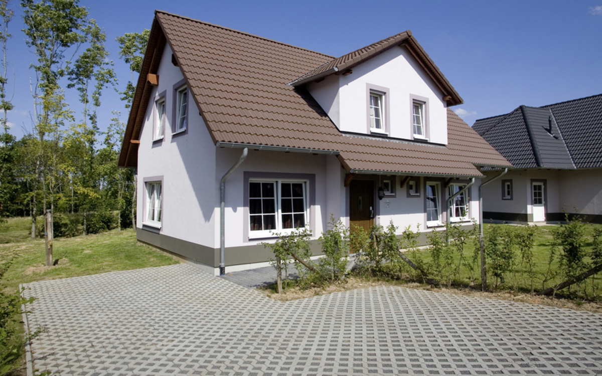 Rasengitterplatten in Grau vor einem Hauseingang mit Gartenanlage