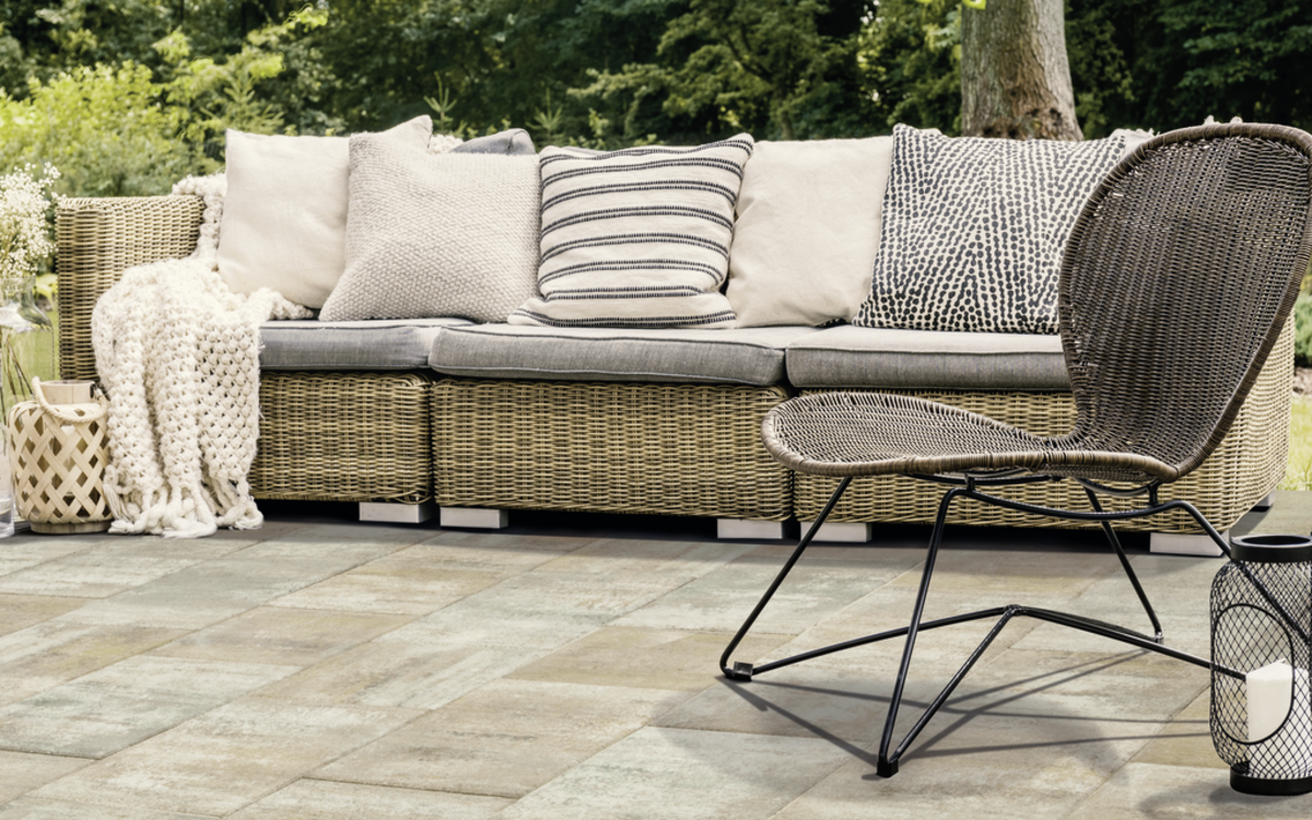 Terrassenplatten in hellem Grau mit Möbeln auf einer Terrasse im Garten