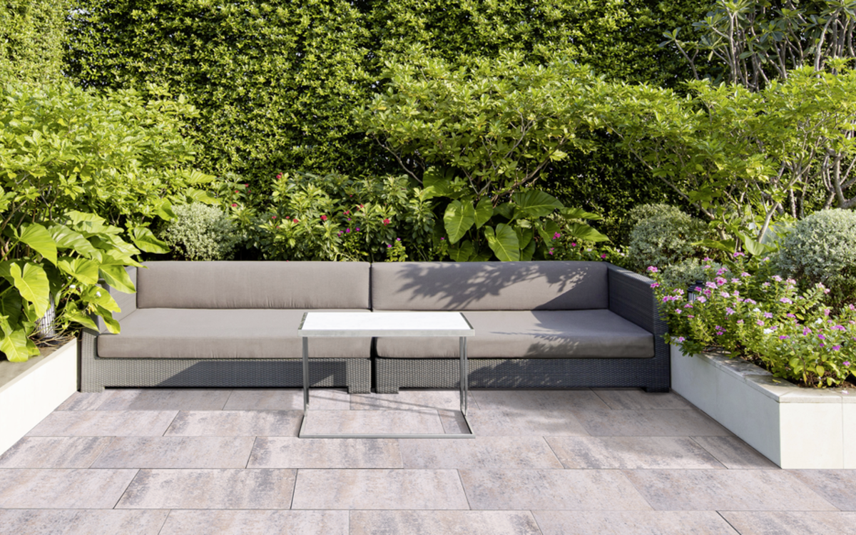 Helle Terrassenplatten auf einer Garten-Terrasse mit Lounge-Bereich
